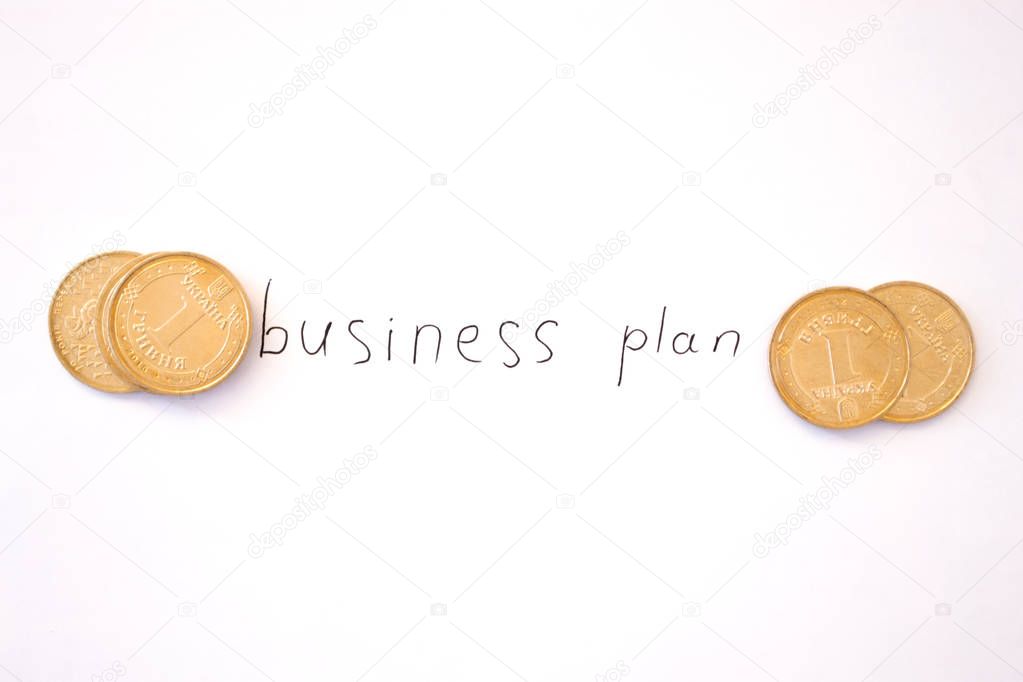 Inscription on white background business plan with coins.
