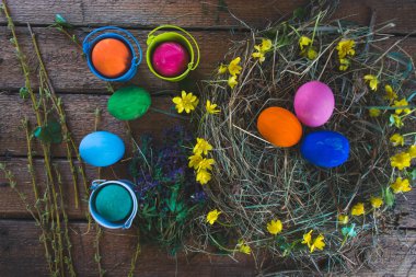 Çok renkli Paskalya yumurta yuvada ahşap arka plan üzerinde.