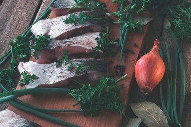 Ahşap bir gemide baharat ve maydanoz ile taze balık dilimlenmiş.