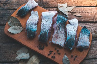 Ahşap bir gemide baharat ve maydanoz ile taze balık dilimlenmiş.