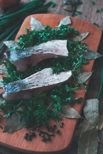 木の板にスパイスとパセリと新鮮な魚の薄切り. — ストック写真