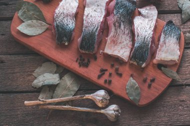 Çiğ balık ile ahşap bir zemin üzerine baharat pişirme.