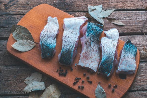 Сырая рыба со специями на деревянной доске
.