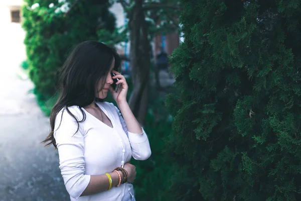 Menina bonita nova no parque com telefone móvel . — Fotografia de Stock