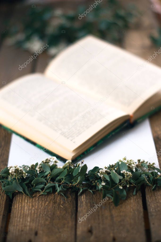 Lilac branches on a wooden background with a book.