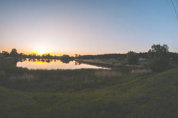 Večer při západu slunce v den letní krajina na rybník. — Stock fotografie