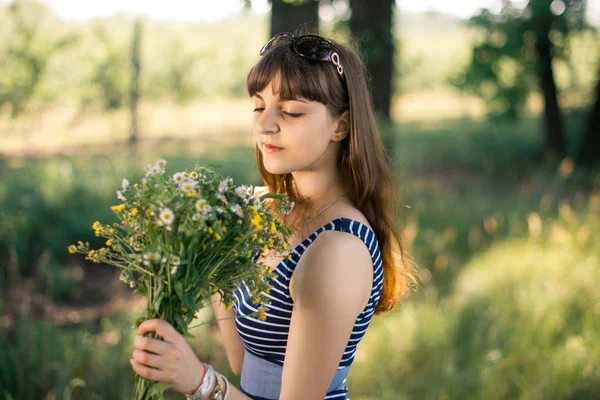 Ragazza con un mazzo di fiori selvatici in natura . — Foto Stock