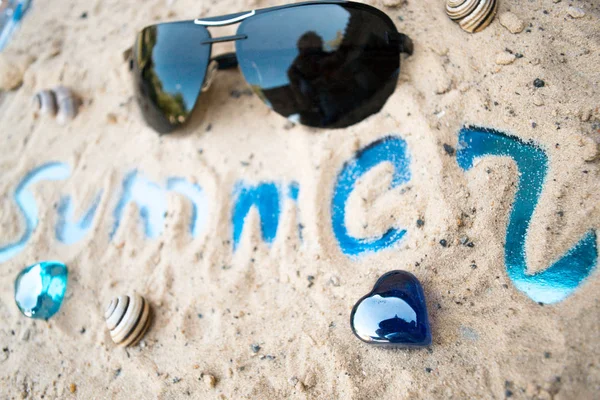 Schwarze Sonnenbrille an einem sonnigen Sandstrand. — Stockfoto