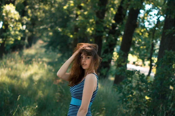 Vinden blåser håret av en ung flicka på en sommar. — Stockfoto
