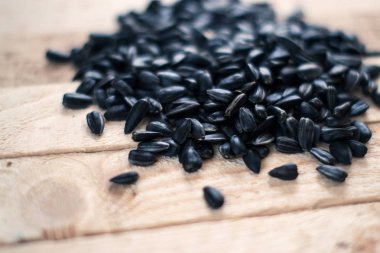 Ahşap oyun tahtası üzerinde arka plan bulanık ayçiçeği tohumu.