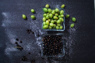 Natürmort bir tabak içinde siyah bir zemin üzerine yaz taze çilek.