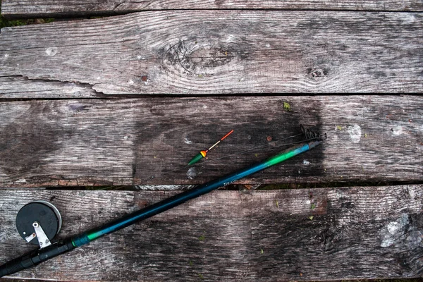 Rybářské potřeby, tyč na dřevěné pozadí. — Stock fotografie
