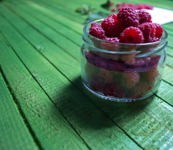 Taze olgun ahududu yeşil ahşap kurullarında.