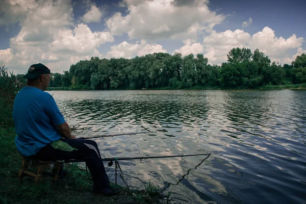 Un pescador captura peces en un estanque en una mañana soleada de verano . — Foto de Stock