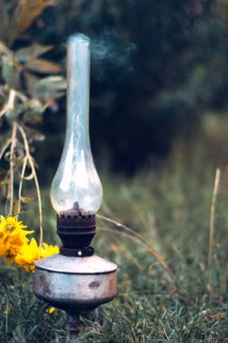 Bir sigara eski gaz lambası yeşil çimenlerin üzerinde.