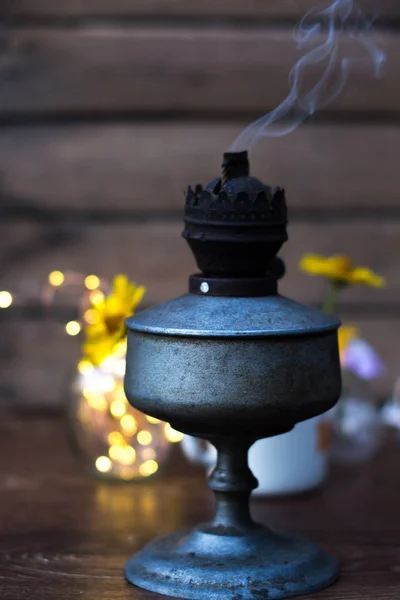 Uma antiga lâmpada de querosene para fumar em um fundo de madeira . — Fotografia de Stock