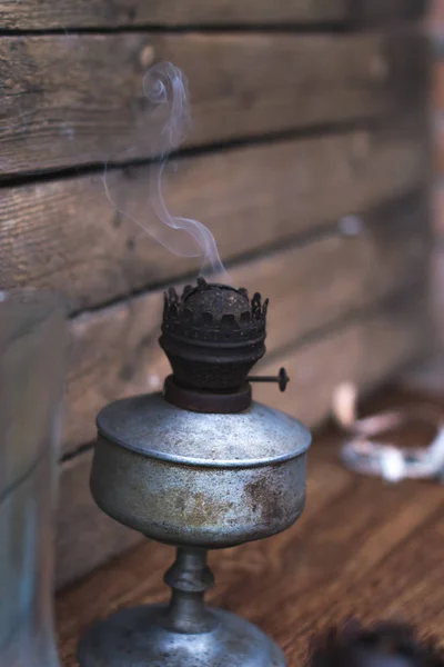 Uma antiga lâmpada de querosene para fumar em um fundo de madeira . — Fotografia de Stock