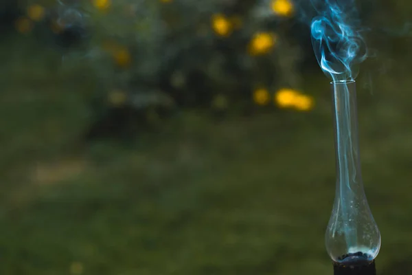 Eine rauchende alte Petroleumlampe auf einem grünen Gras. — Stockfoto