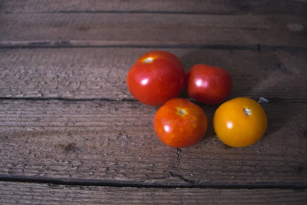 Tomates frescos em um fundo velho de madeira . — Fotografia de Stock