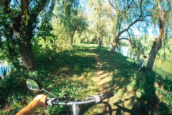 Велосипедні керма, на яких рука велосипедиста знаходиться біля ставка . — стокове фото