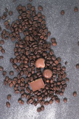 Kahve çekirdekleri ve fayans mat koyu arka plan üzerinde koyu çikolata.