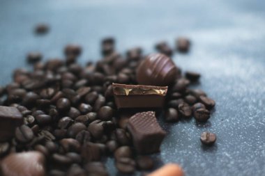 Kahve çekirdekleri ve fayans mat koyu arka plan üzerinde koyu çikolata.