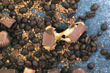 Kahve çekirdekleri ve fayans mat koyu arka plan üzerinde koyu çikolata.