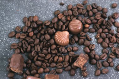 Kahve çekirdekleri ve fayans mat koyu arka plan üzerinde koyu çikolata.