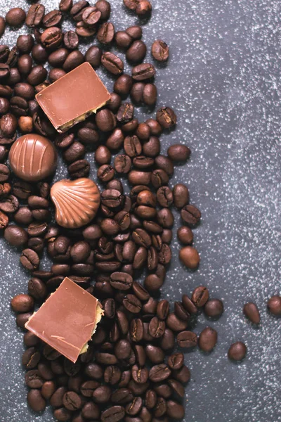 Kahve çekirdekleri ve fayans mat koyu arka plan üzerinde koyu çikolata.