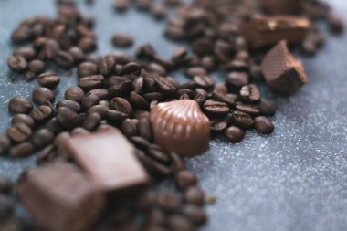 Kahve çekirdekleri ve fayans mat koyu arka plan üzerinde koyu çikolata.