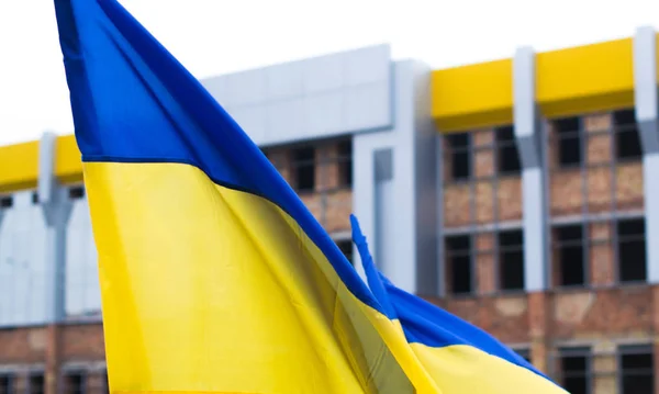 Ukrainian flag on the background of unfinished building.