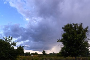 Akşam fırtına bulutları köyü peyzaj üzerinde.