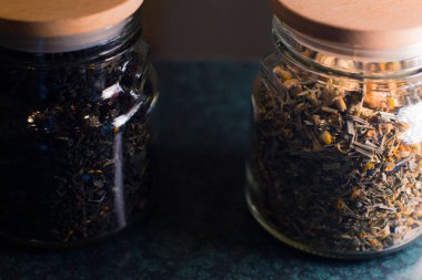 Çay bulanık bir arka plan üzerinde cam kavanozlara farklı türleri.