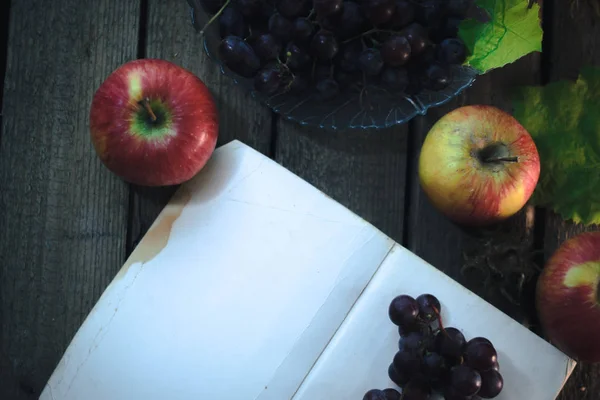 Autumn still life: Grapes with a book on a wooden background. — Stock Photo, Image