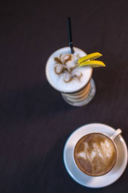 İki bardak kahve ile arka plan bulanık bir kafede.