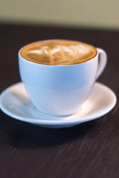 Uma xícara de café com uma foto em um café . — Fotografia de Stock