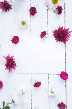 Beyaz ahşap mocap arka plan üzerinde renkli çiçekler.