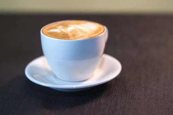 Una taza de café con una foto en un café . — Foto de Stock