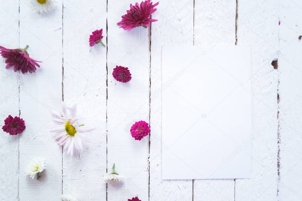 Multicolored flowers on a white wooden mocap background.