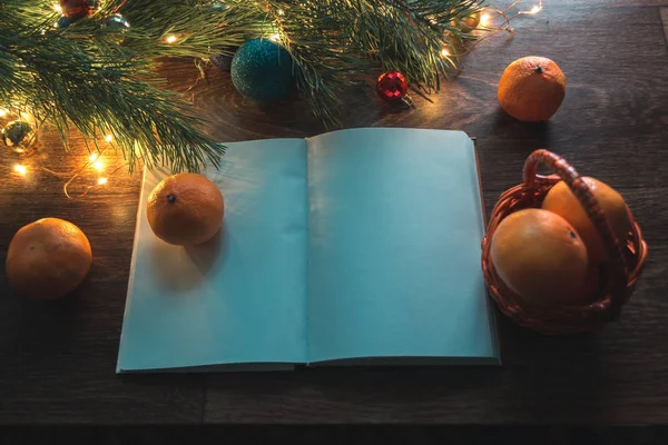Open notebook on a wooden background with Christmas decorations. Mocap. — Stock Photo, Image