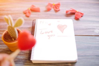 Yazıt üzerinde ahşap arka plan üzerinde beyaz bir not defteri seniseviyorum