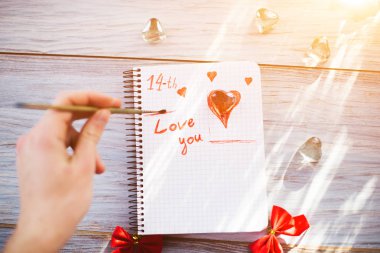 Bir adam bir metni bir beyaz kağıda yazar.