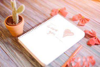 Yazıt üzerinde ahşap arka plan üzerinde beyaz bir not defteri seniseviyorum