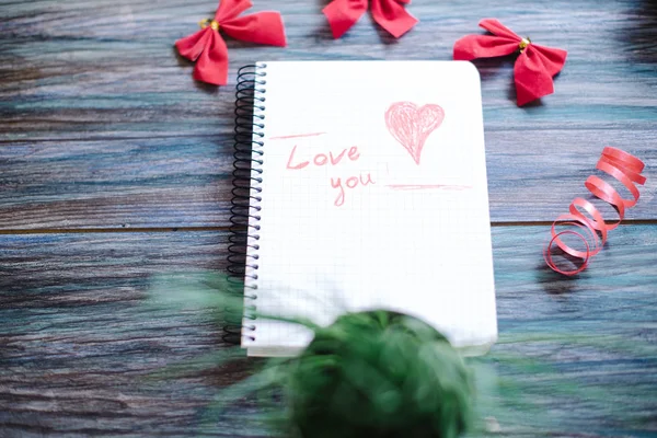 Napis kocham Cię na biały Notatnik na podłoże drewniane — Zdjęcie stockowe