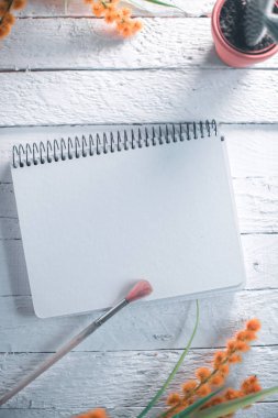 Kaktüs bir ahşap beyaz zemin üzerine not defteri.