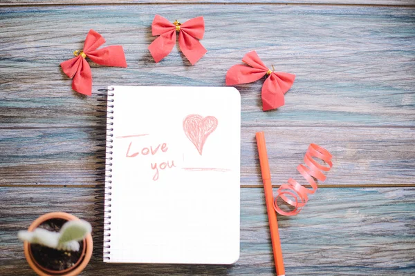 Επιγραφή σε αγαπώ σε ένα άσπρο σημειωματάριο σε φόντο ξύλινη — Φωτογραφία Αρχείου