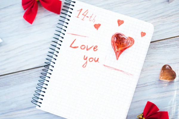 Επιγραφή σε αγαπώ σε ένα άσπρο σημειωματάριο σε φόντο ξύλινη — Φωτογραφία Αρχείου