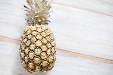 Eski bir ahşap zemin üzerine Bütün Konfit bir ananas.