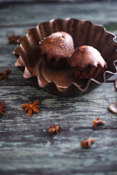 Koyu ahşap arka plan gül dalları ile cupcakes.
