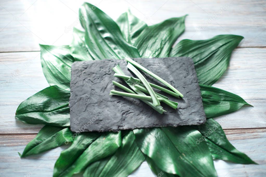 Sliced green stems on a black kitchen board